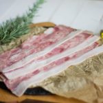 Tocineta de cerdo en tiras, 500 g al vacío sobre papel con romero – Cortes & Brasas